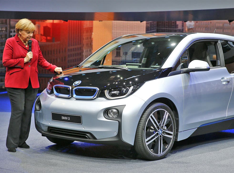 Angela Merkel speaks next to the new BMW i3 electric car