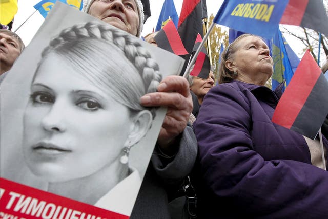 Ukrainians hold Ukrainian Insurgent Army (UPA) flags and portraits of jailed opposition leader Yulia Tymoshenko in Kiev earlier this week