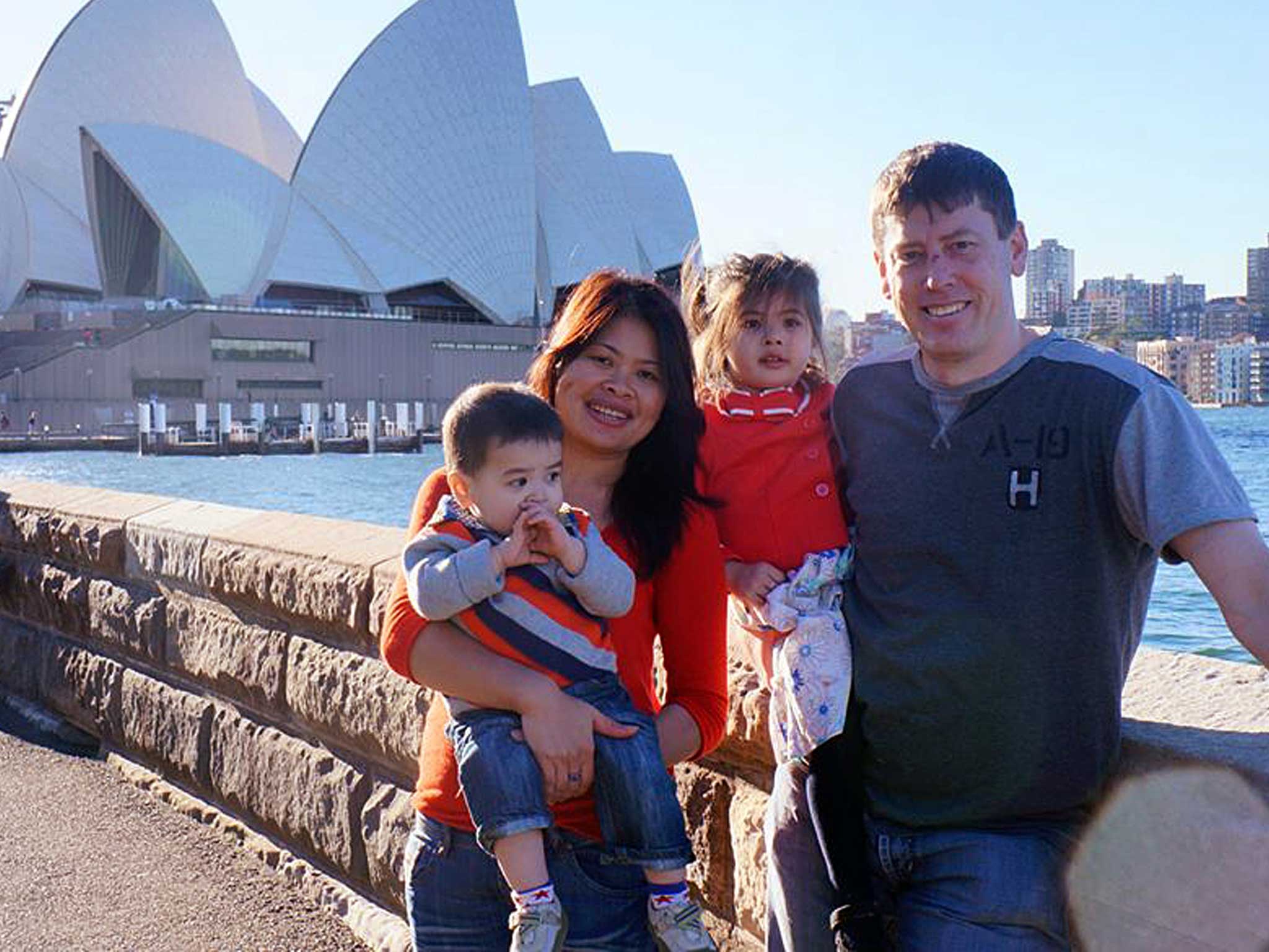 Phoumalaysy Rhodes, second left, and her husband Gavin Rhodes, right, hold their children Manfred and Jadesuda