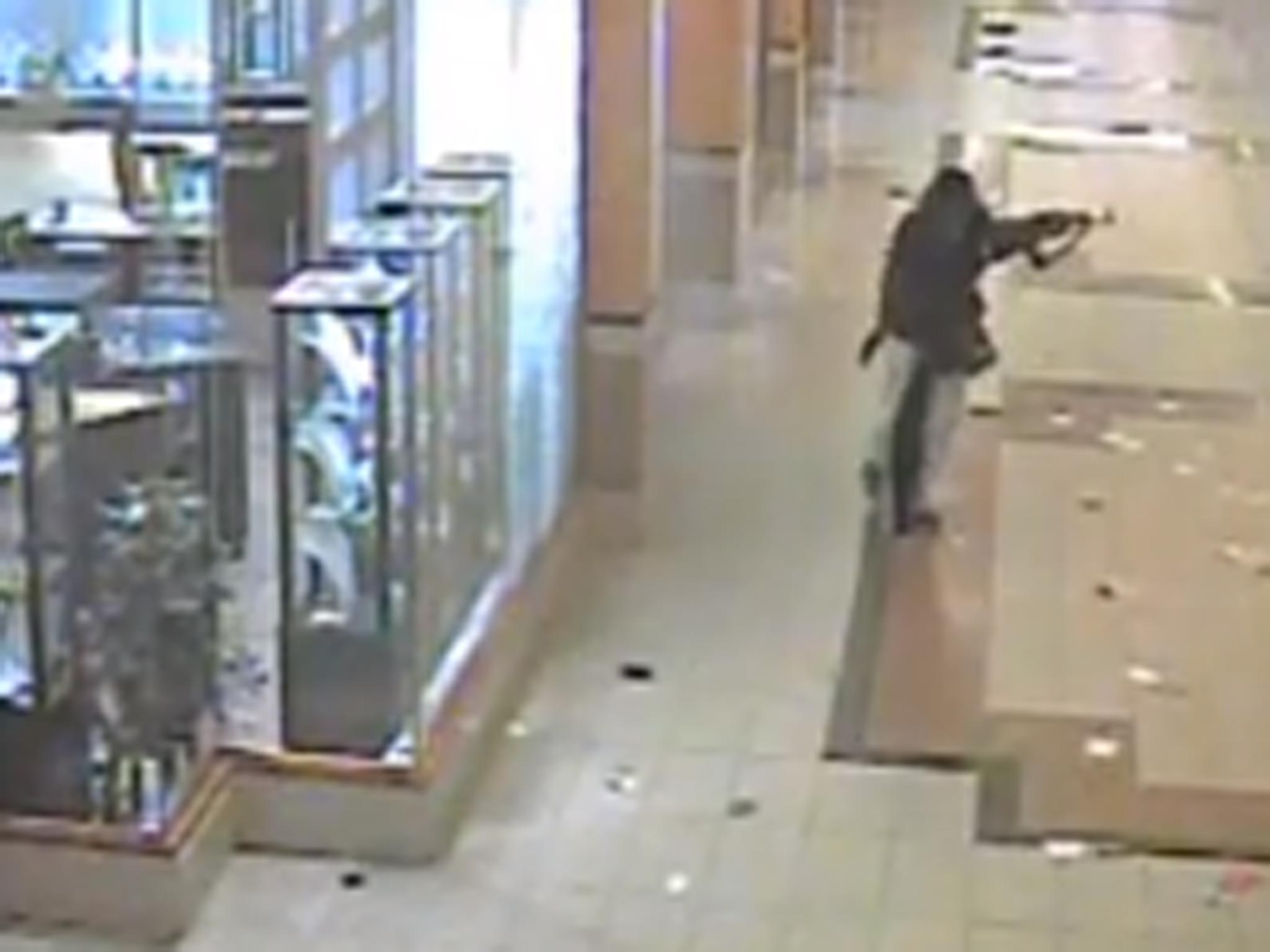 A gunman walks through the corridors of the mall