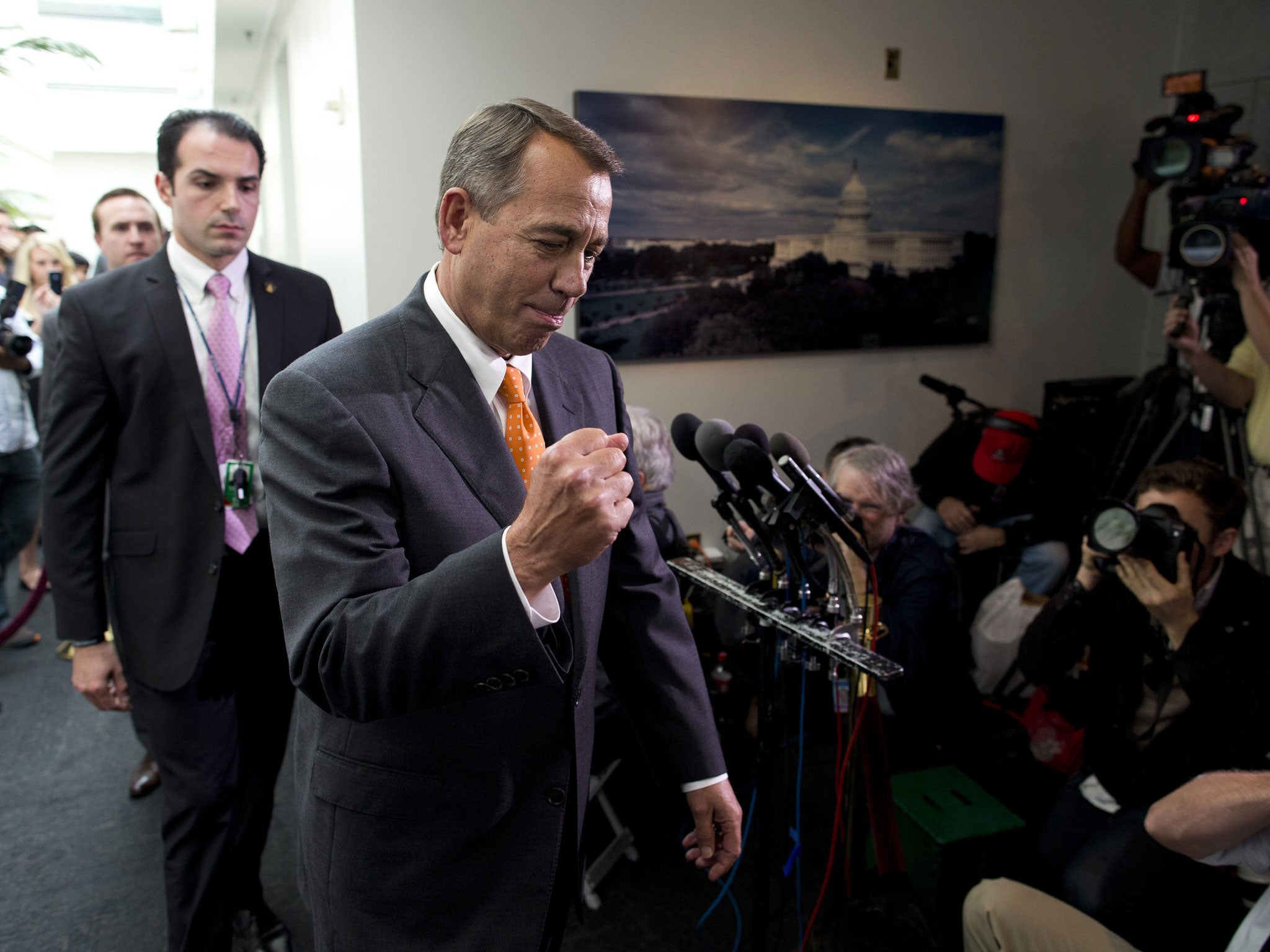 Speaker of the House Rep. John Boehner, R-Ohio, pumps his fist as he walks past reporters after a meeting with House Republicans