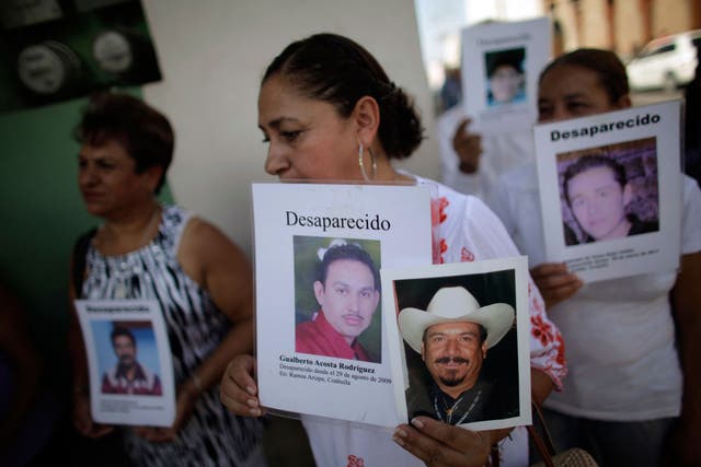 Women hold posters of their missing relatives in Saltillo