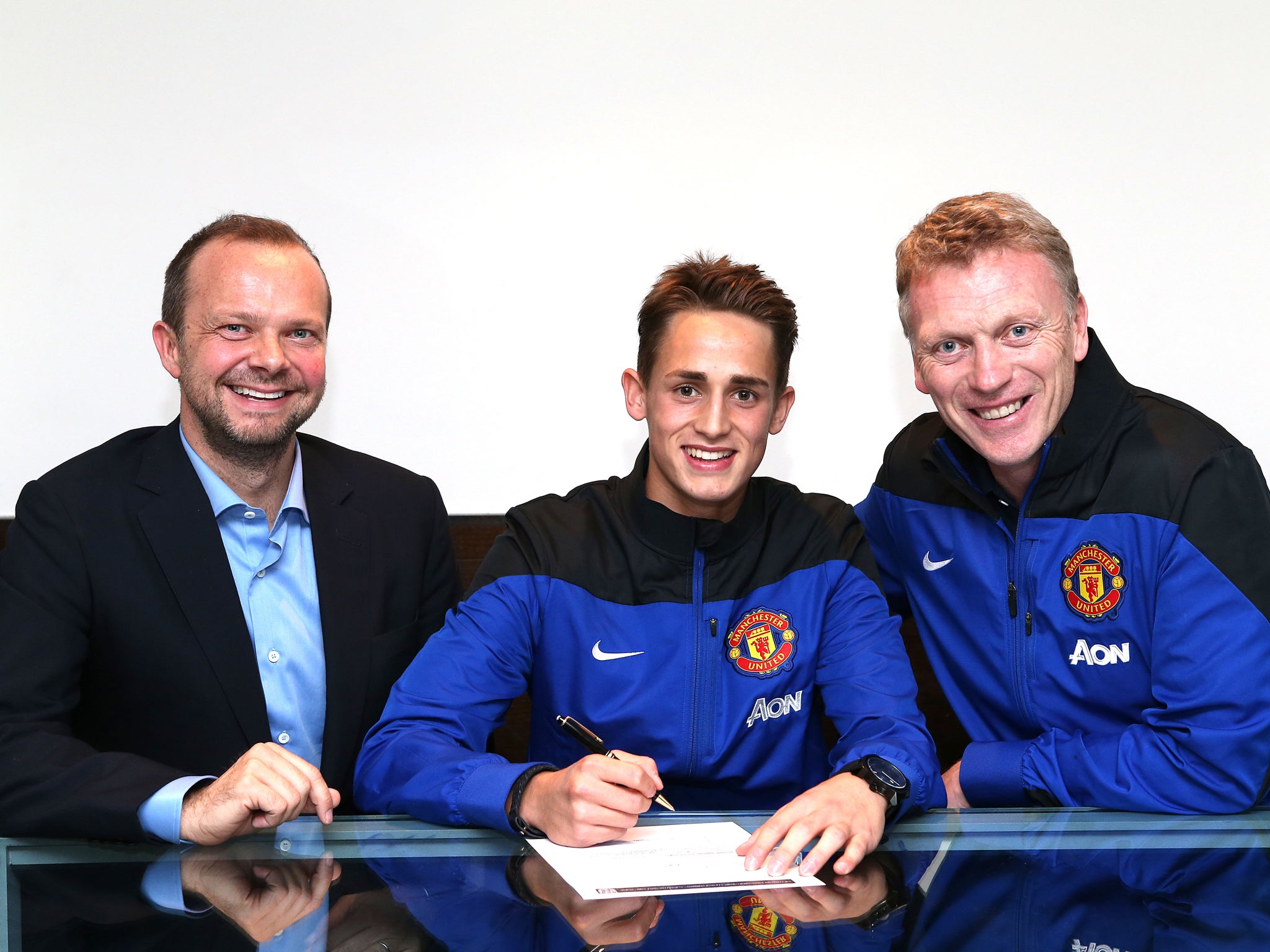 Adnan Januzaj (C) signs a new five-year contract with Manchester United alongside chief executive Ed Woodward (L) and manager David Moyes (R)