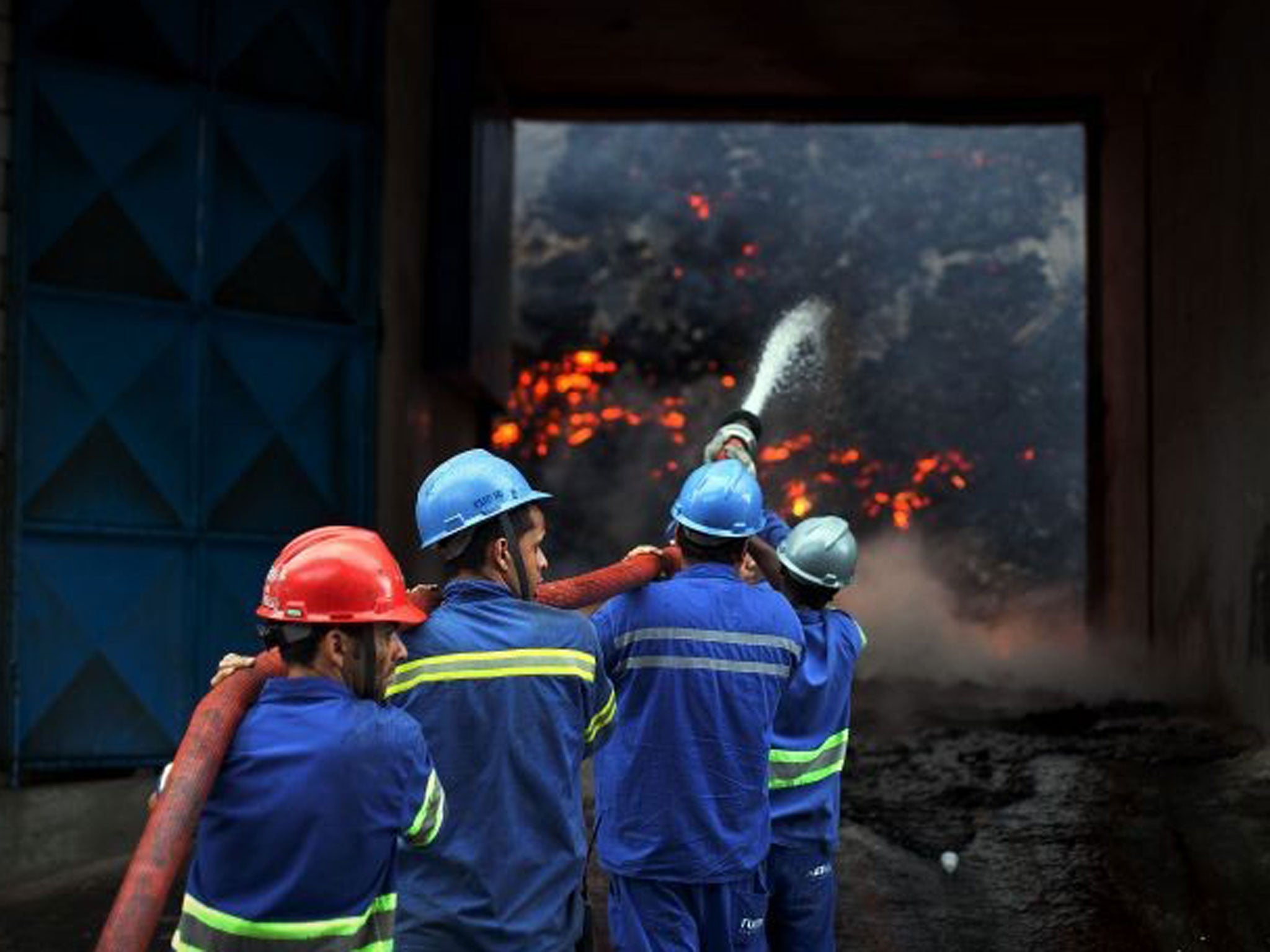 Firefighters attempt to extinguish a fire in a warehouse with sugar at the port of Santos, the biggest of Latin America, some 60 km of Sao Paulo, Brazil on 18 October, 2013.