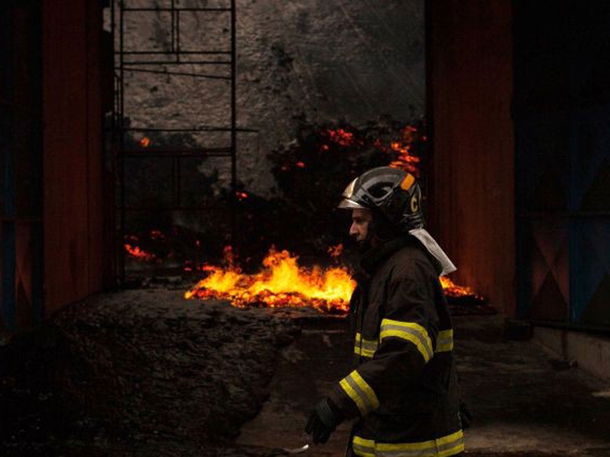 A firefighters works on extinguish a fire in a warehouse with sugar at the port of Santos