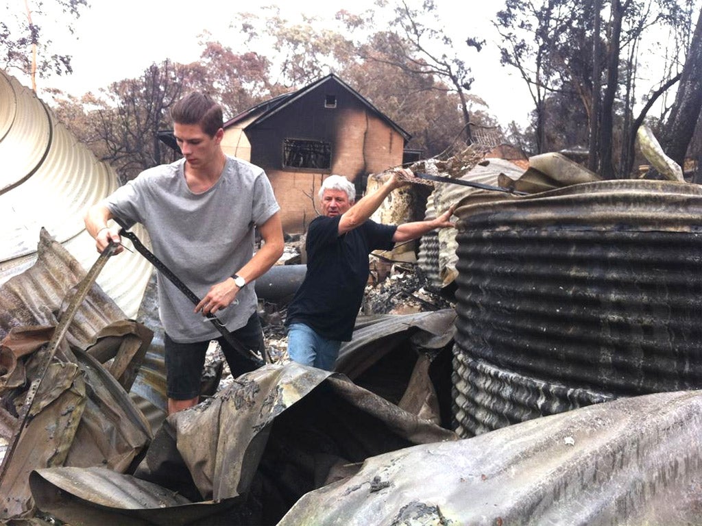 Ron Fuller and his son search through the rubble of their home