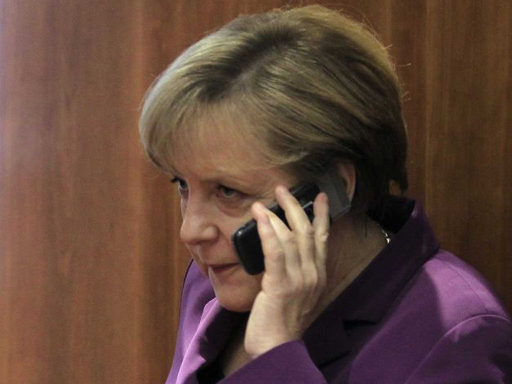 Angela Merkel using her phone two years ago; she is now demanding an apology from Obama after records appear to show the US tapping her calls
