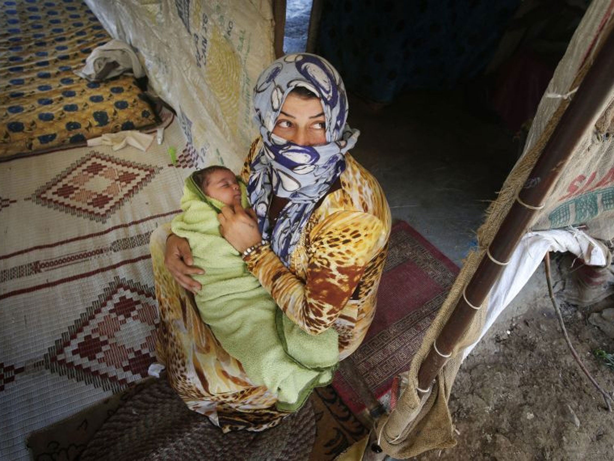 Syrian refugee Shaha Ibrahim and her two month-old daughter Bayane, who fled their home in Syria after 18 days of fighting that killed two of Shaha's cousins