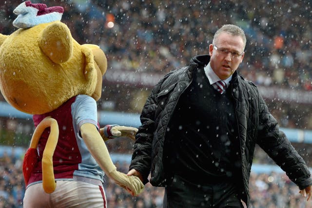Manager Paul Lambert of Aston Villa shakes hands with the mascot