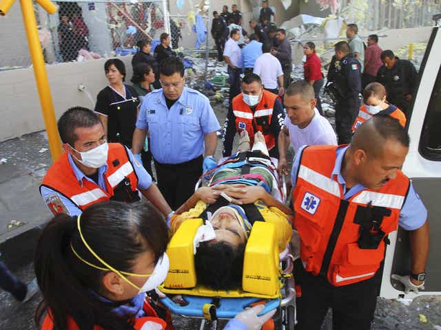 Paramedics move an injured person to an ambulance outside a sweet factory in Ciudad Juarez, Mexico