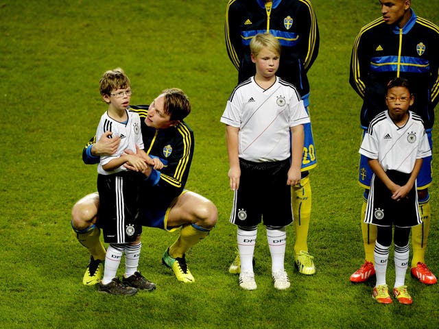 Swedish midfielder Kim Kallstrom comforts an agitated mascot named Max