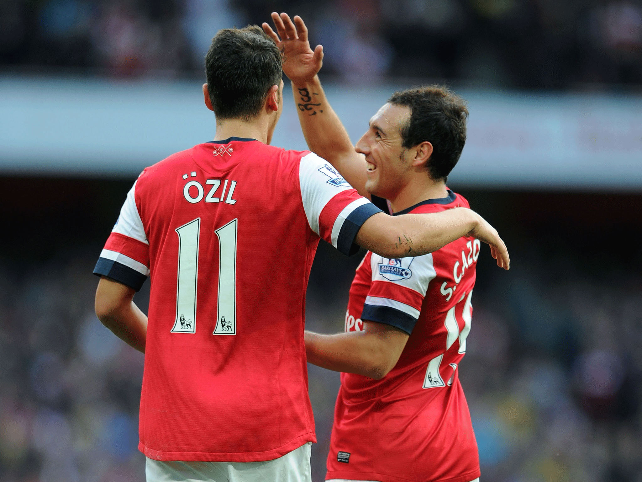 Mesut Oezil celebrates scoring Arsenal's 2nd goal with Santi Cazorla