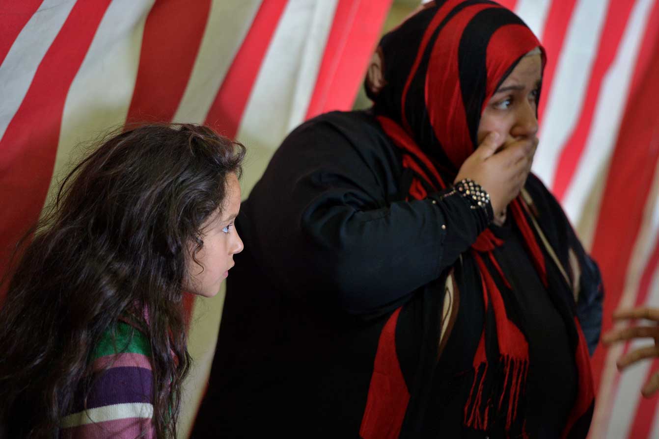 A woman and her daughter stand inside the Italian navy amphibious assault ship San Marco after being rescued off the island of Lampedusa on 25 October 2013