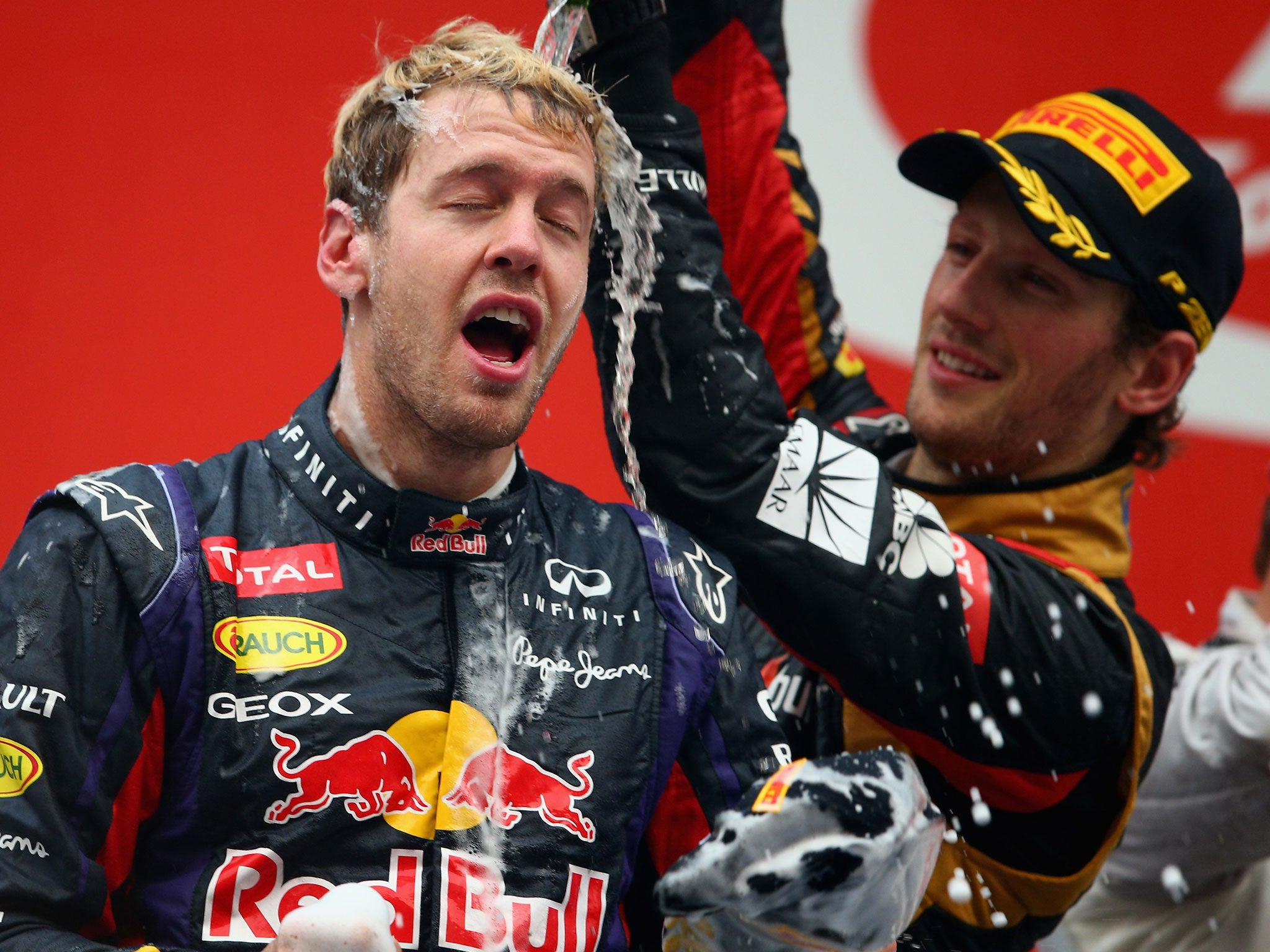 NOIDA, INDIA - OCTOBER 27: Race winner and 2013 Formula One World Champion Sebastian Vettel (L) of Germany and Infiniti Red Bull Racing celebrates with third placed Romain Grosjean (R) of France and Lotus following the Indian Formula One Grand Prix