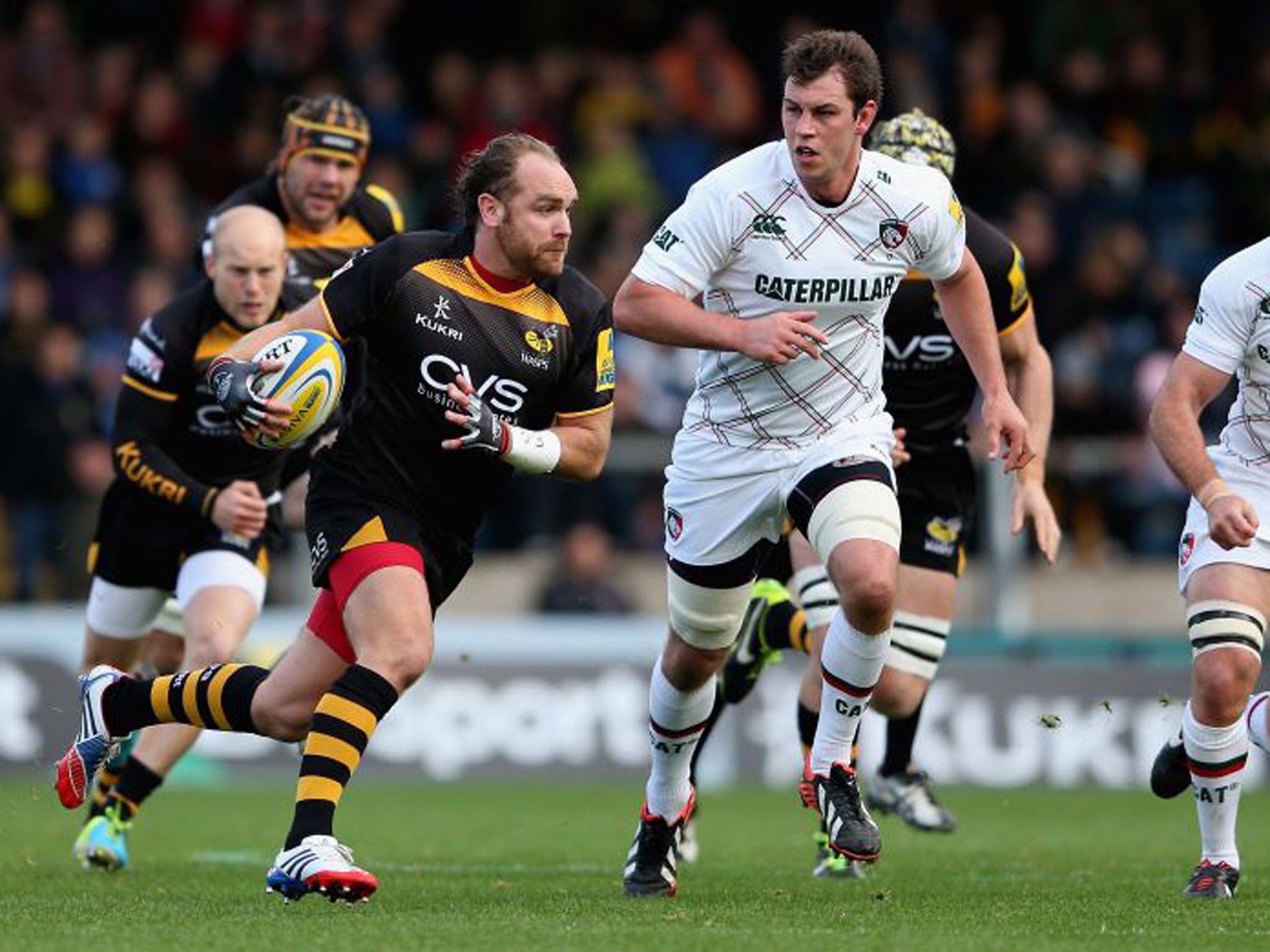 Wasps’ Andy Goode (left) makes a break against Leicester