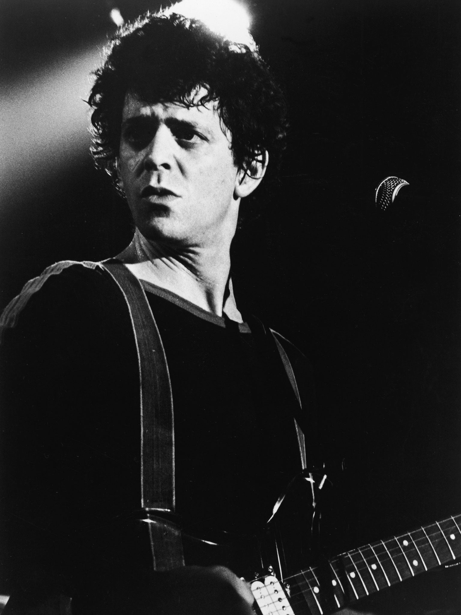 Portrait of American rock and roll musician Lou Reed on stage with a guitar, 1970s