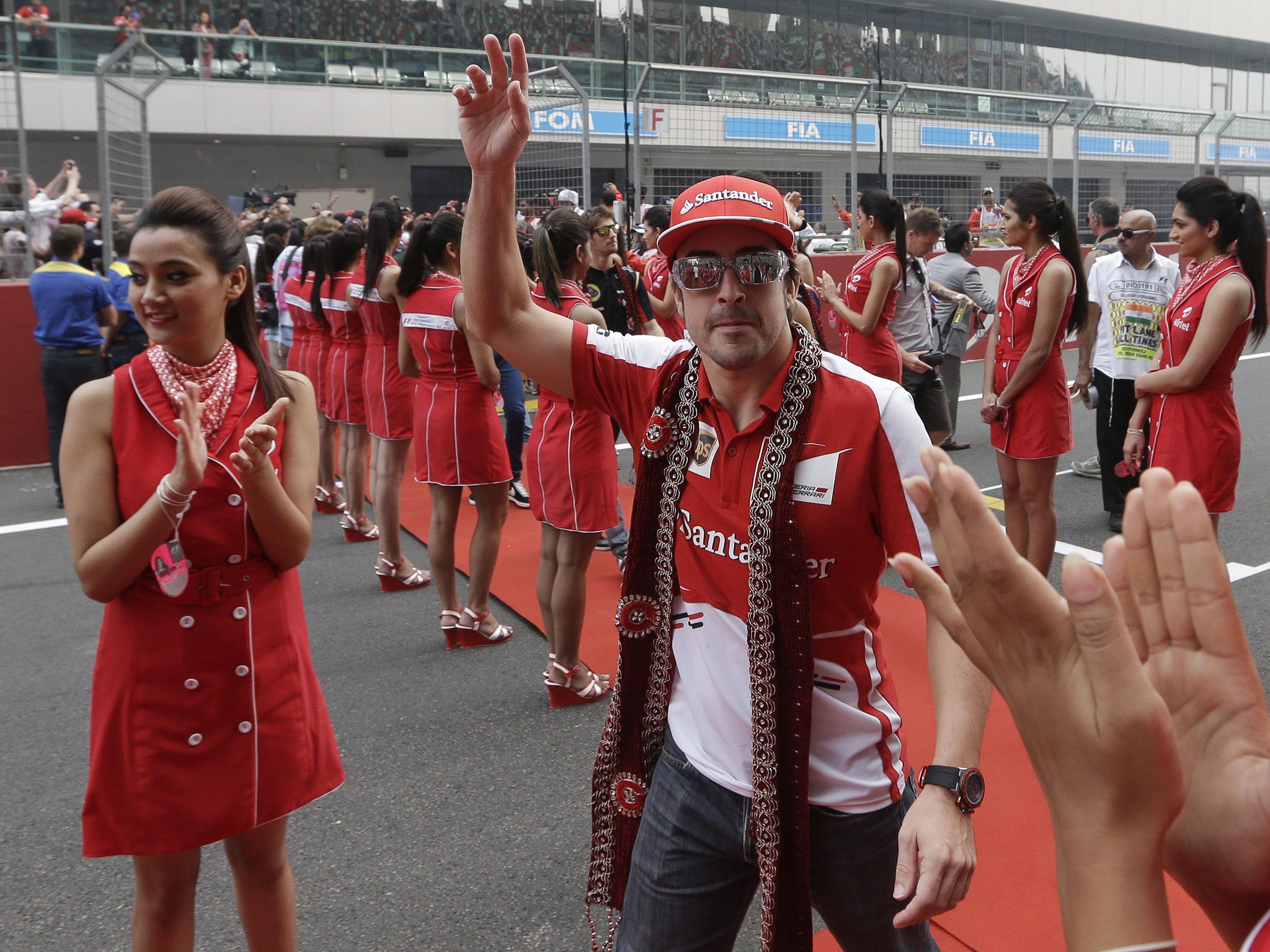 Fernando Alonso waves to the crowd during the drivers’ parade