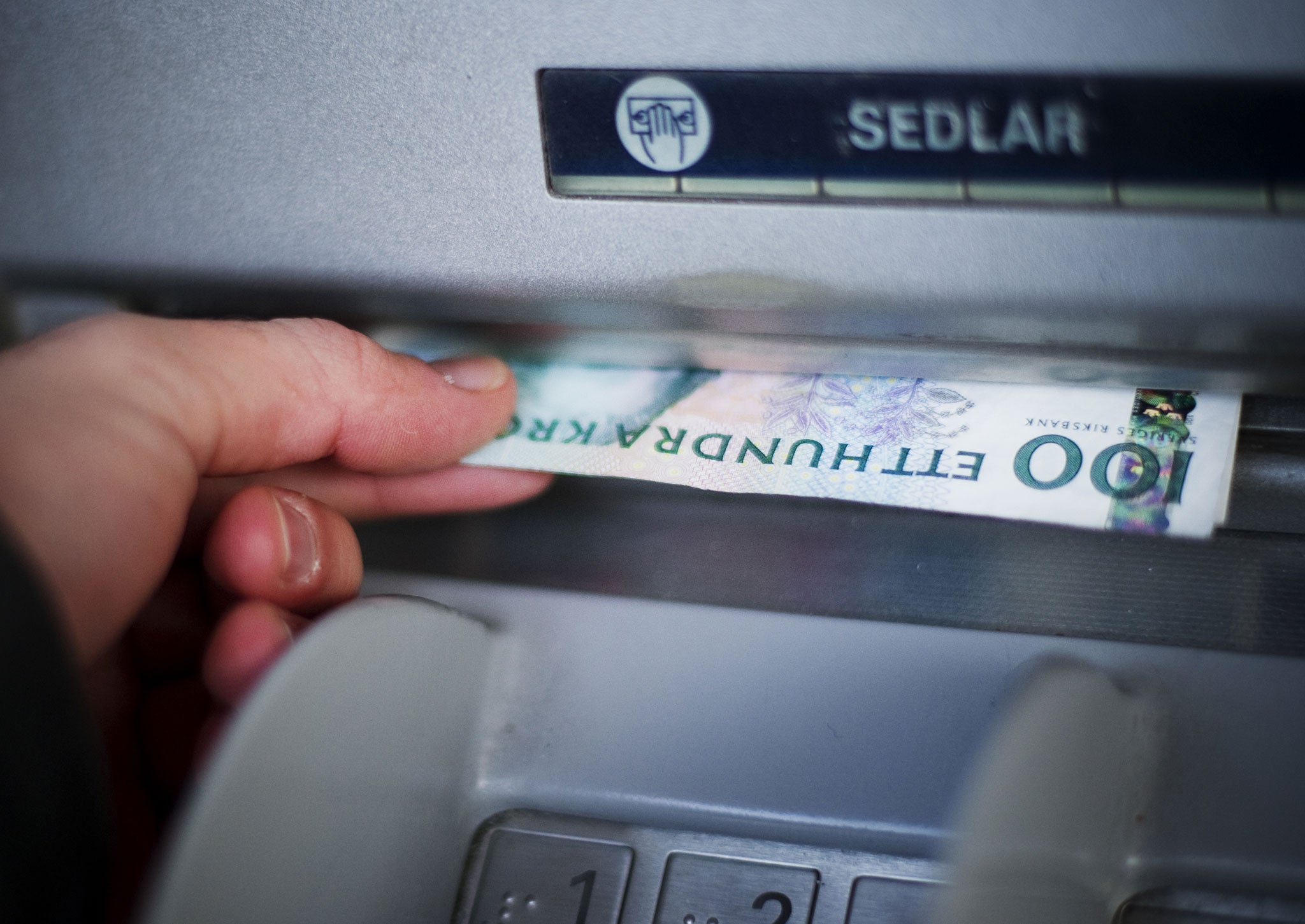 In the most cashless society on the planet, Swedish Crowns currency banknotes are withdrawn from an ATM machine in Stockholm