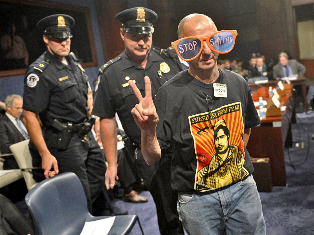 A protester is removed from the hearing during recess