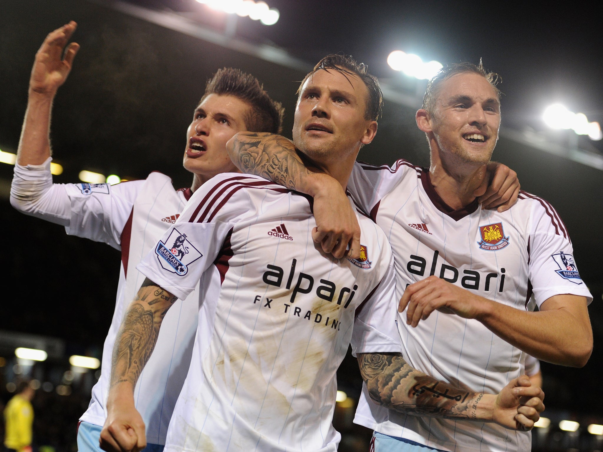 West Ham players Daniel Potts (L), Matt Taylor (C) and Jack Collison (R) celebrate after they take the lead against Burnley