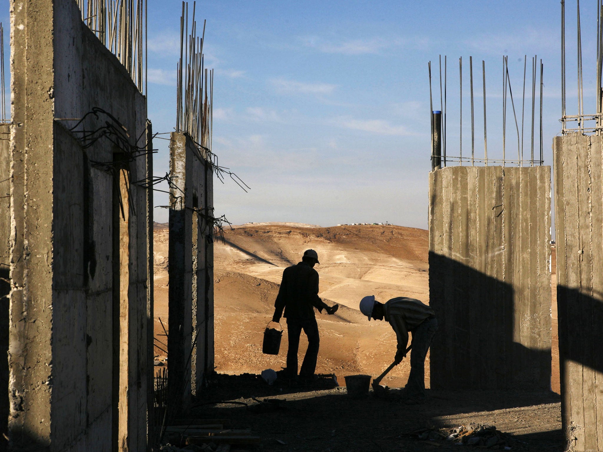 Palestinian construction laborers work on a new housing development in the West Bank Jewish settlement of Maaleh Adumim, near Jerusalem. Israel has announced plans to build 1,500 new homes in east Jerusalem, the part of the city claimed by the Palestinian