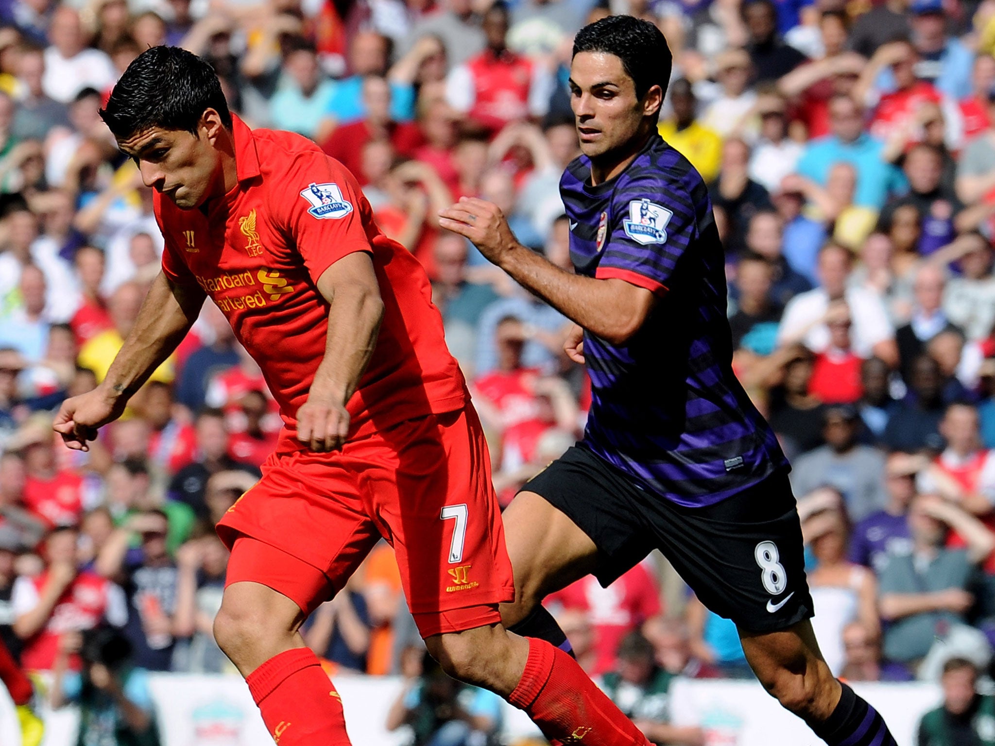 Luis Suarez (left) is pursued by Mikel Arteta during Arsenal's 2-0 win at Liverpool in the Premier League in September 2012