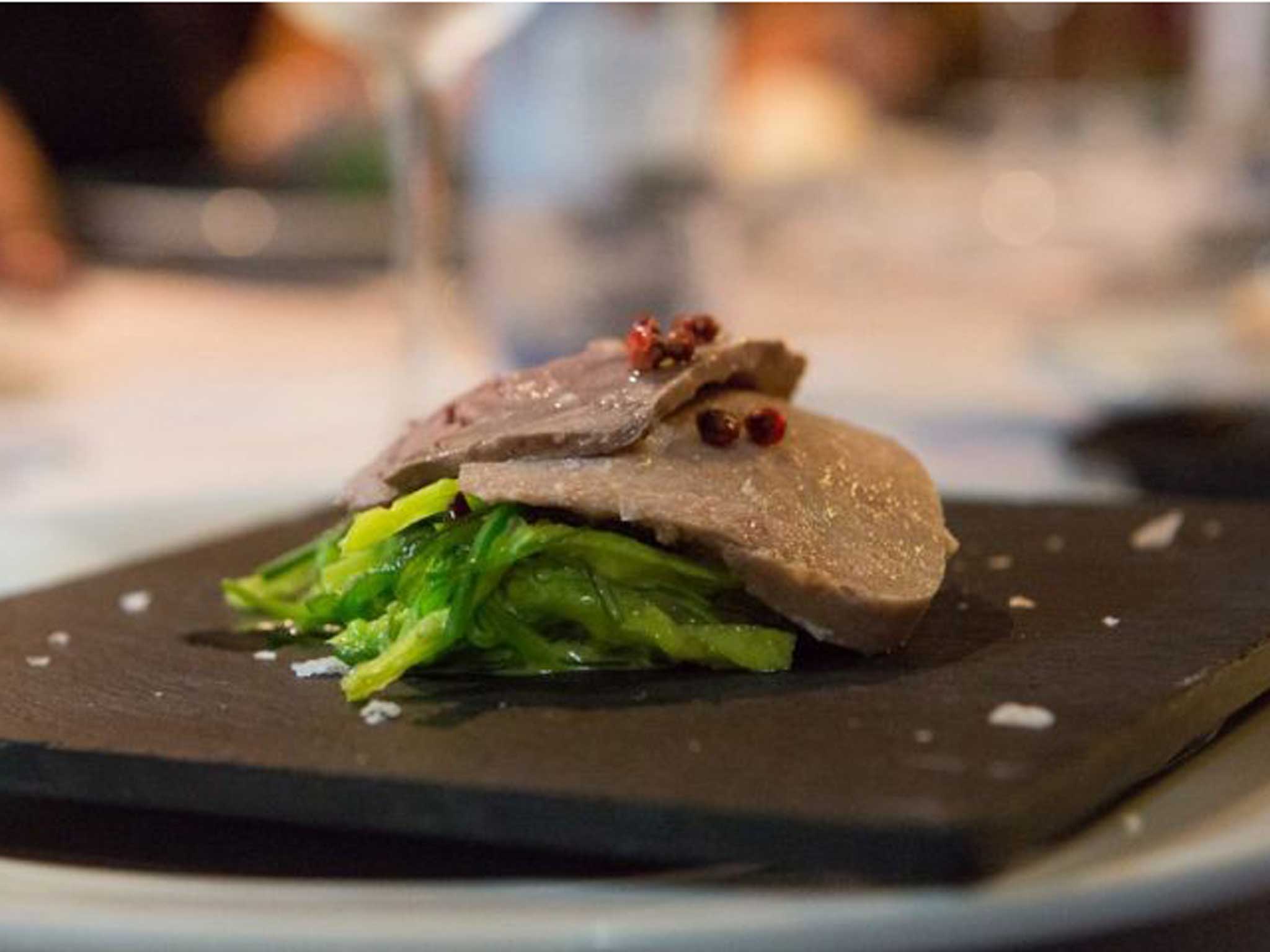 Thin slices of fish slow cooked on a bed of wakame seaweed