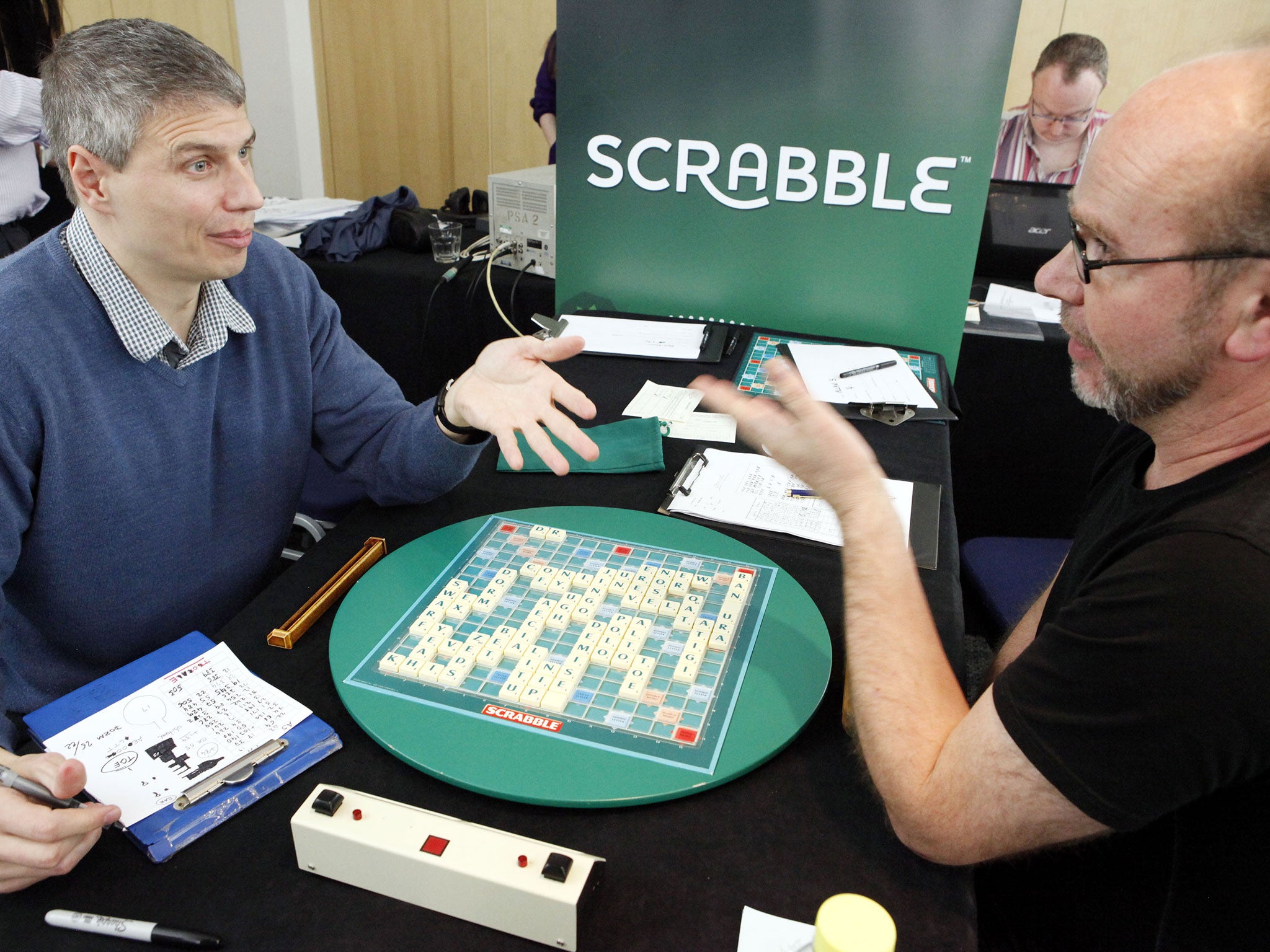 Paul Allan, left, discusses his winning board with defeated opponent Allan Simmons, right, at the 42nd British National Scrabble Championships in London
