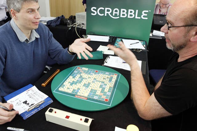 Paul Allan, left, discusses his winning board with defeated opponent Allan Simmons, right, at the 42nd British National Scrabble Championships in London