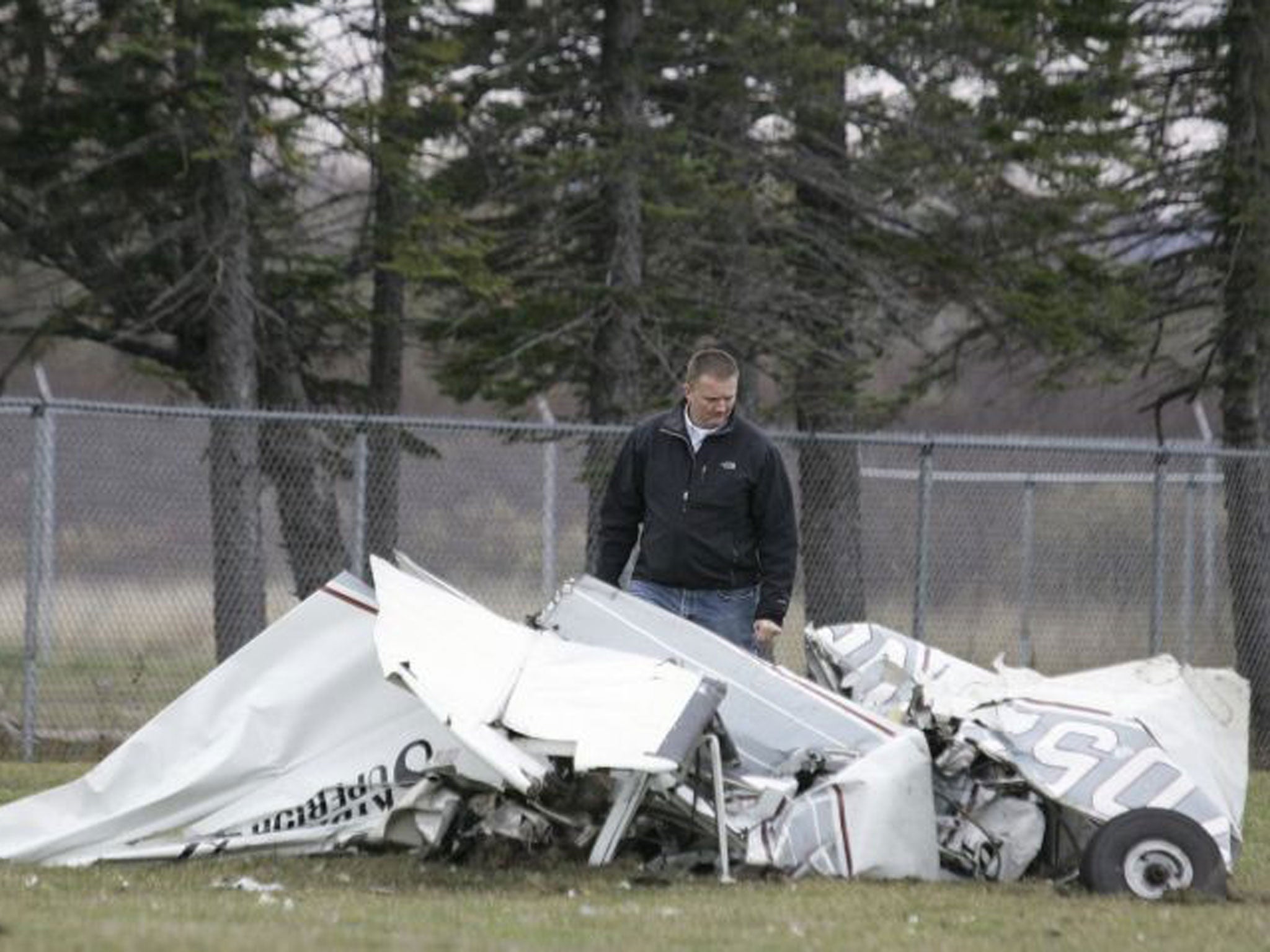 An FAA investigator examines the wreckage of a plane that crashed in Superior, Wis., after a midair collision with another plane