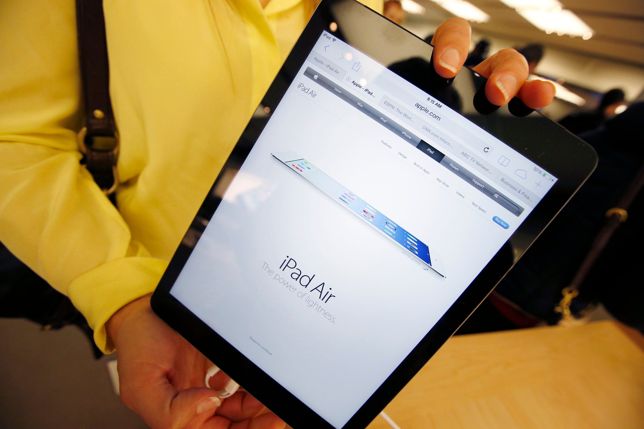 A customer holds a new Apple iPad Air tablet inside the Apple Store on New York's fifth avenue, after the new iPad went on sale, November 1, 2013.