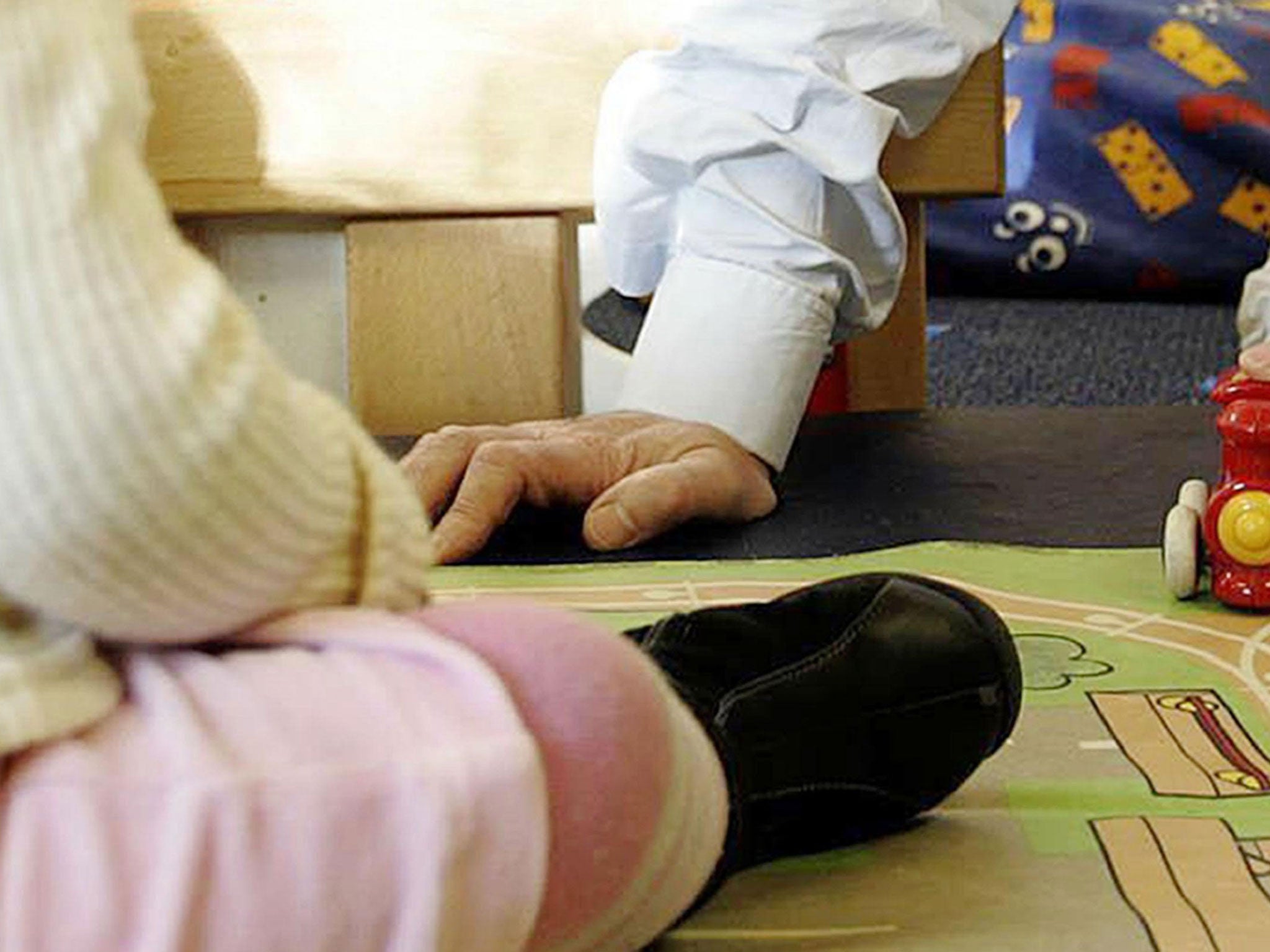 An adult playing with a child at a nursery - a senior Ofsted officer says children should be admitted to school from the age of two to eradicate the effects of poverty on their performance