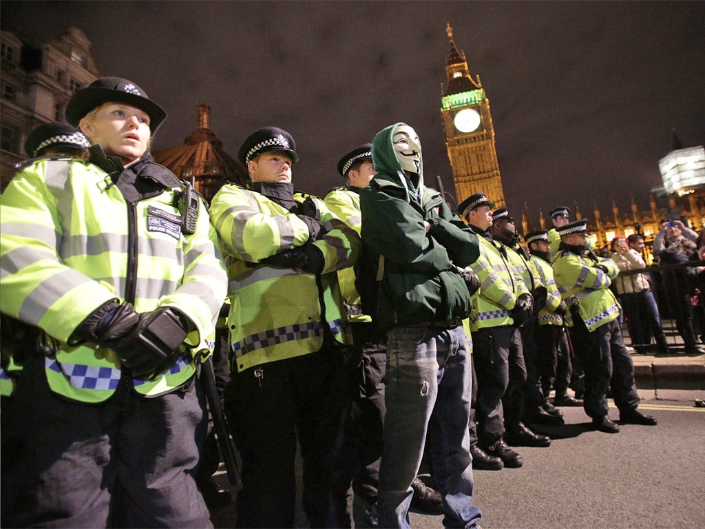 A protester stands in front of a row of police officers