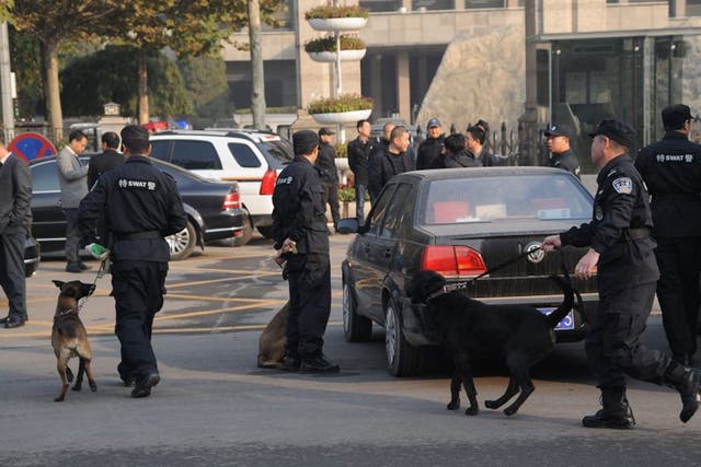 Investigators work at the site of an explosion, outside the provincial headquarters of China's ruling Communist Party in Taiyuan, Shanxi province, China, 6 November 2013.