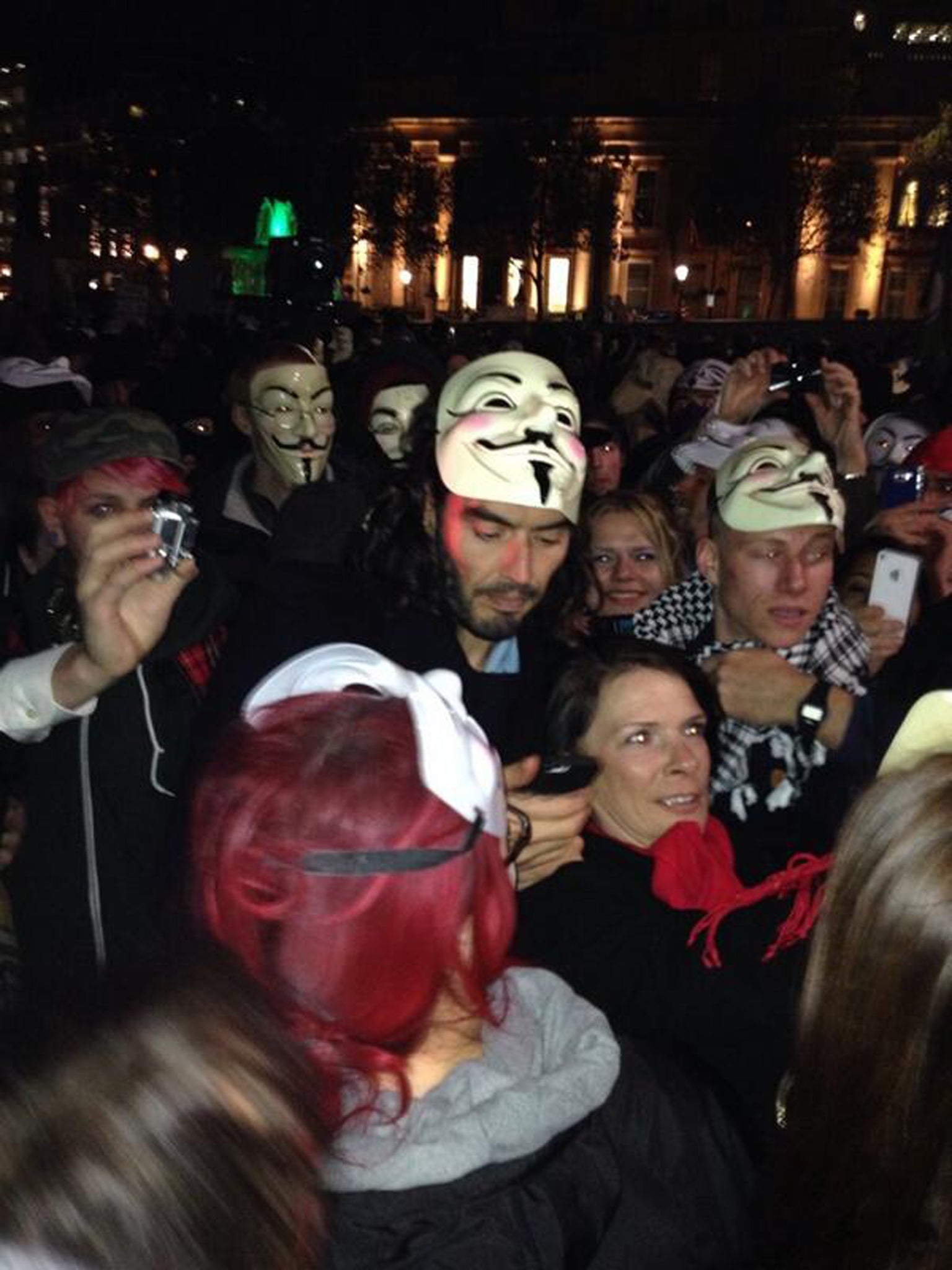 Russell Brand removes his Guy Fawkes mask while on a protest in London organised by Hacktivist group Anonymous 
