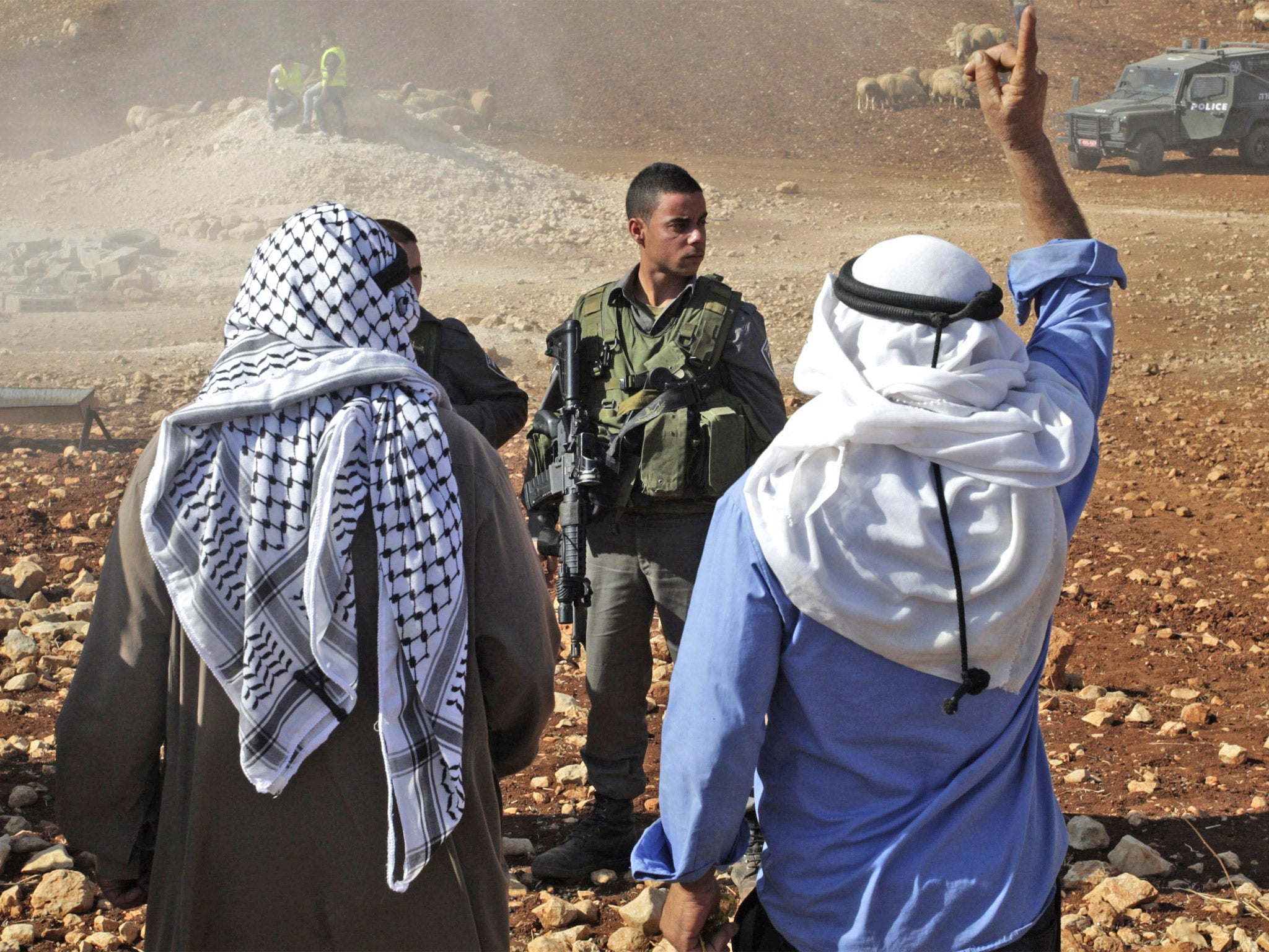 A Palestinian man shouts at Israeli soldiers after the demolition of tin shacks, animal shelters, tents and water wells in Aqraba village, near the settlement of Itamar, Nablus, West Bank