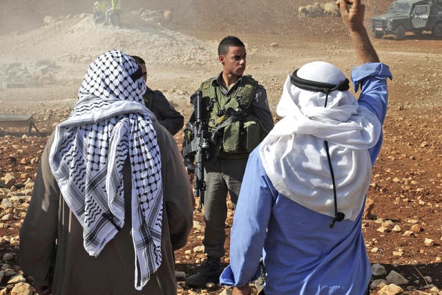 A Palestinian man shouts at Israeli soldiers after the demolition of tin shacks, animal shelters, tents and water wells in Aqraba village, near the settlement of Itamar, Nablus, West Bank