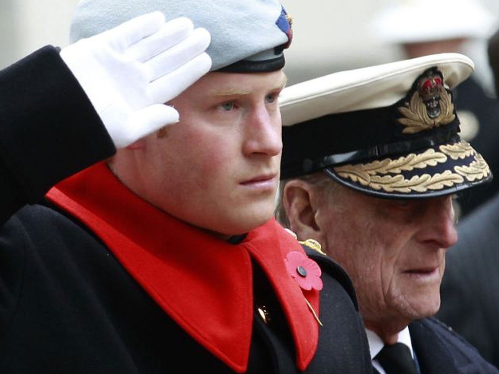 7 November 2013: Prince Harry salutes as he stands with Prince Philip during a visit to the Field of Remembrance at Westminster Abbey. The field commemorates Britain's war dead with crosses and poppies ahead of Remembrance Sunday