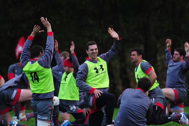 George North (centre) shares a joke with his team-mates during the warm-up in training