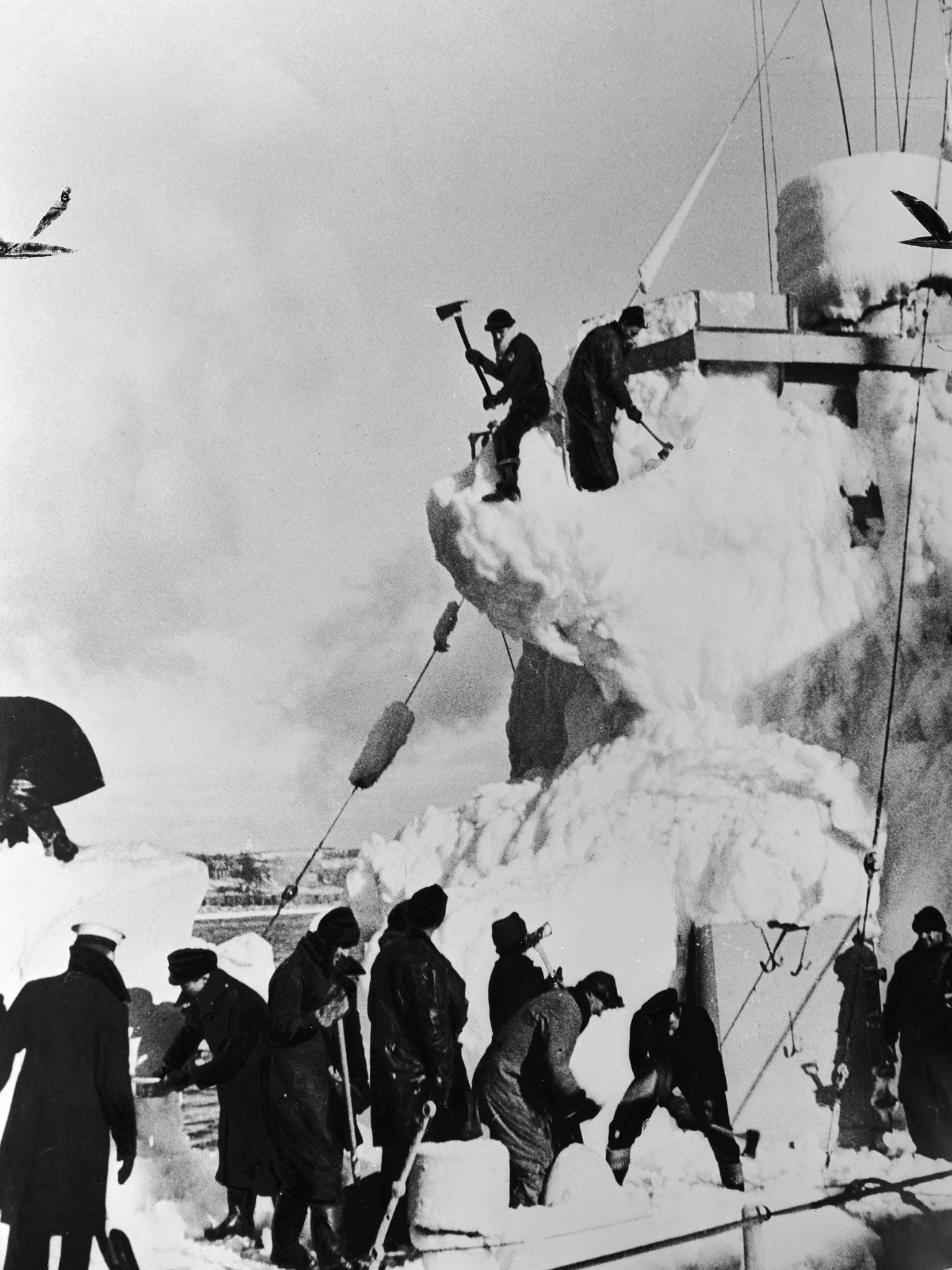 The crew of a British destroyer clear the snow and ice from her decks, whilst on convoy escort duty in the North Atlantic, 11th April 1943 (Getty)
