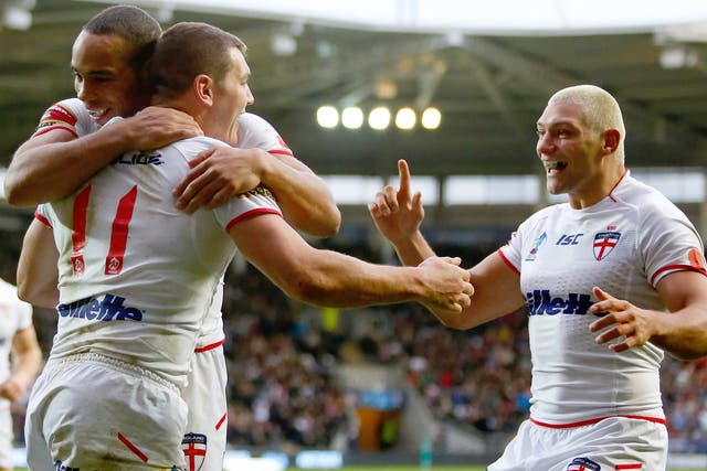 Brett Ferres (C) of England celebrates his try with team mates Leroy Cudjoe (L) and Ryan Hall during the Rugby League World Cup Group A match against Fiji