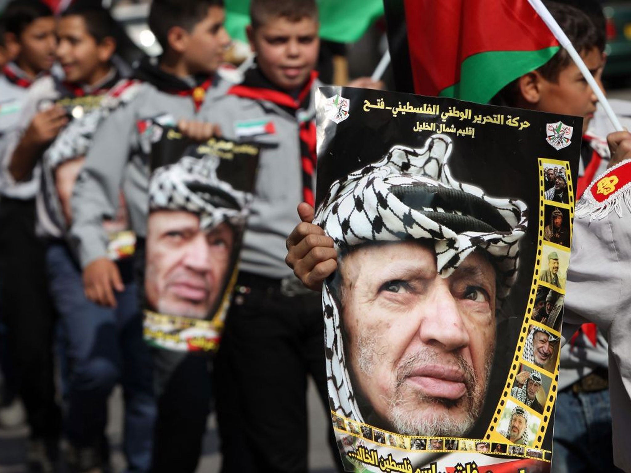 11 November 2013: Palestinian youth hold portraits of late Palestinian leader Yasser Arafat during a march in the West Bank town of Hebron to mark the ninth anniversary of Arafat's death