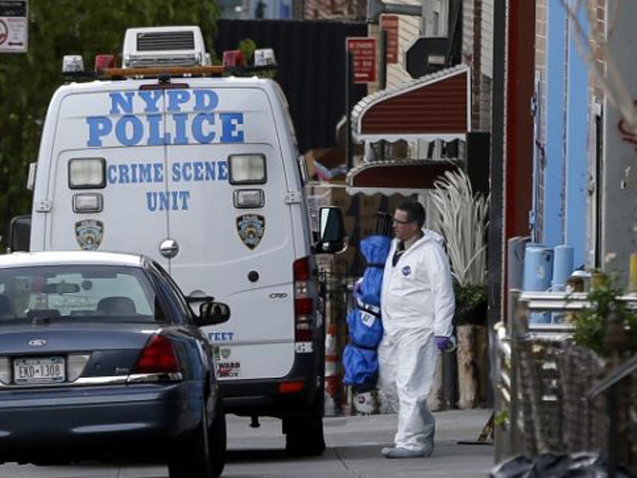 Crime scene personnel work at a crime scene in the Brooklyn section of New York. A man who had apparently been kicked out of a band fatally shot three of his bandmates and wounded a fourth