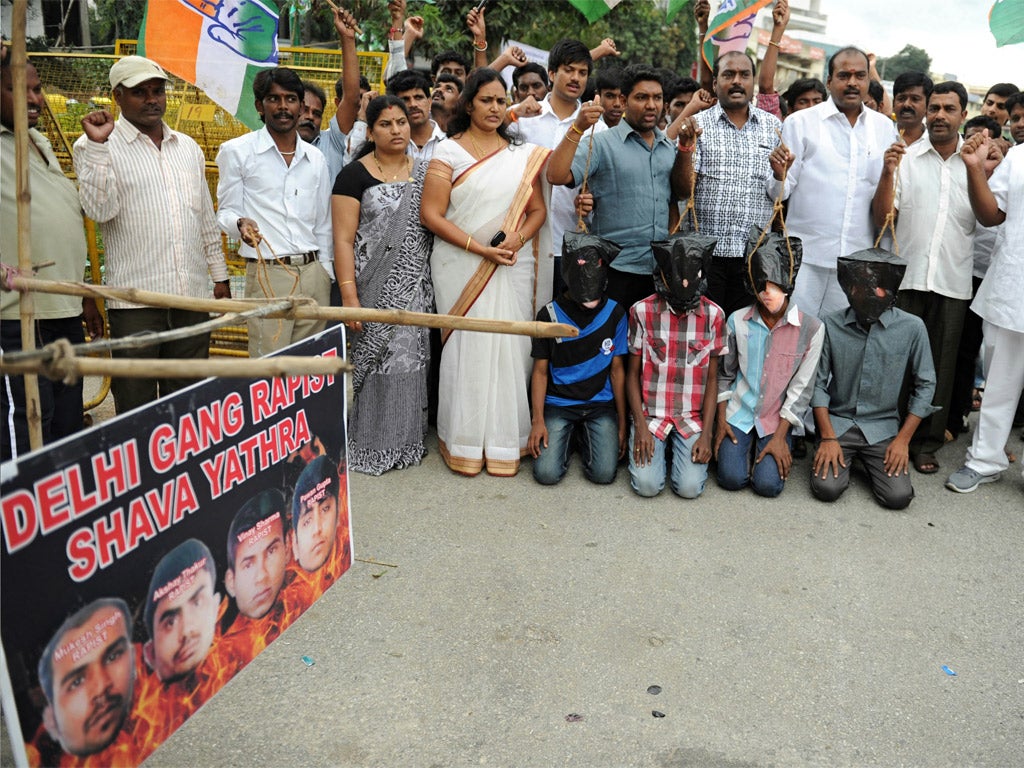 Members of the Karnataka State Youth Congress, some of them wearing masks of the four convicted rapists, enact a mock execution (Getty)