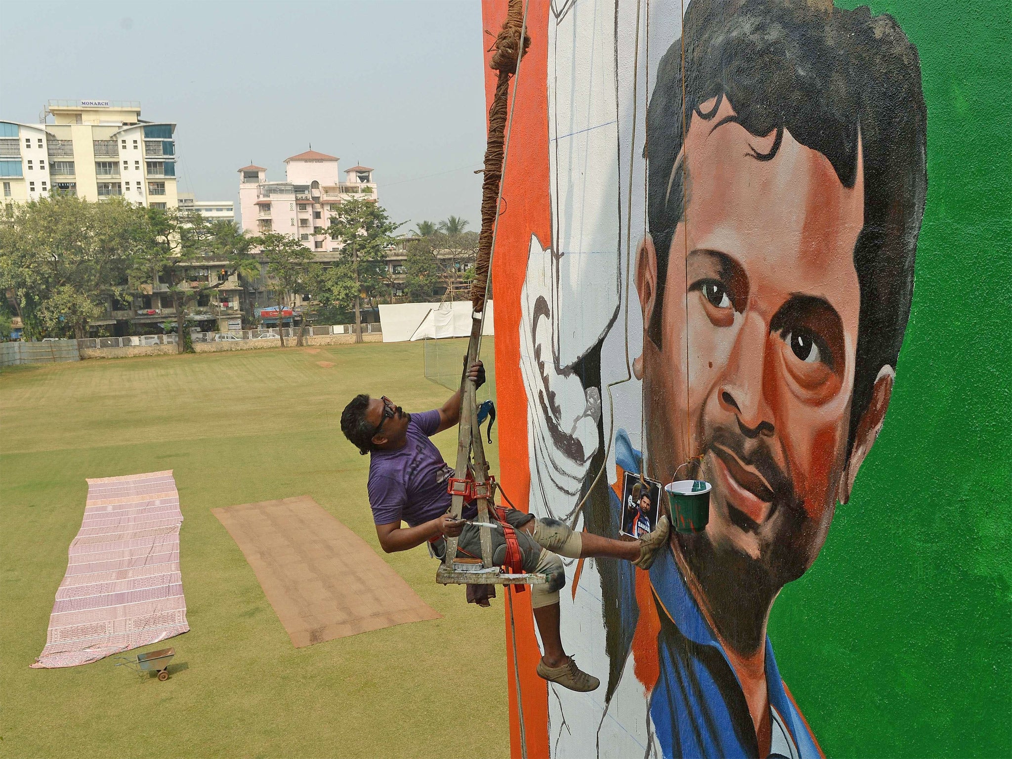 Indian artist Ranjit Dahiya braves the heights as Mumbai prepares for the start of Tendulkar’s final Test match