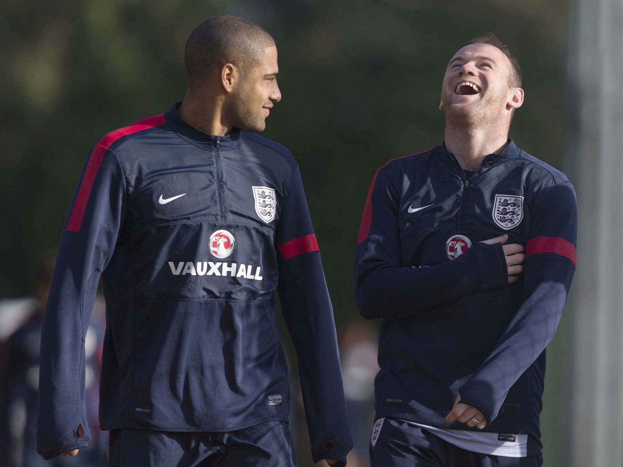 England footballers Glen Johnson (L) and Wayne Rooney (R) share a light moment as they arrive for a training session at Arsenal's training ground