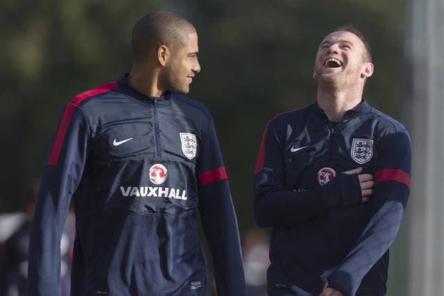 England footballers Glen Johnson (L) and Wayne Rooney (R) share a light moment as they arrive for a training session at Arsenal's training ground