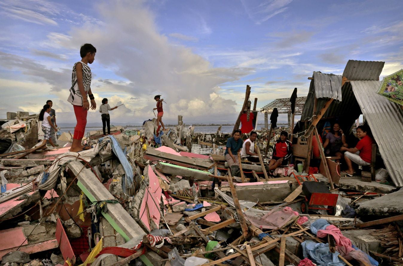Residents gather amongst the devastation in the aftermath of Typhoon Haiyan in Tacloban, Leyte, Philippines.