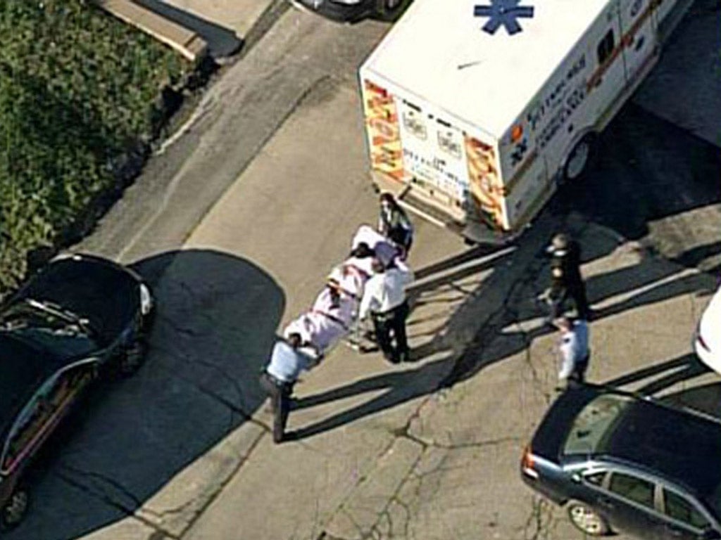 One of the victims is loaded into an ambulance near Brashear High School in Pittsburgh