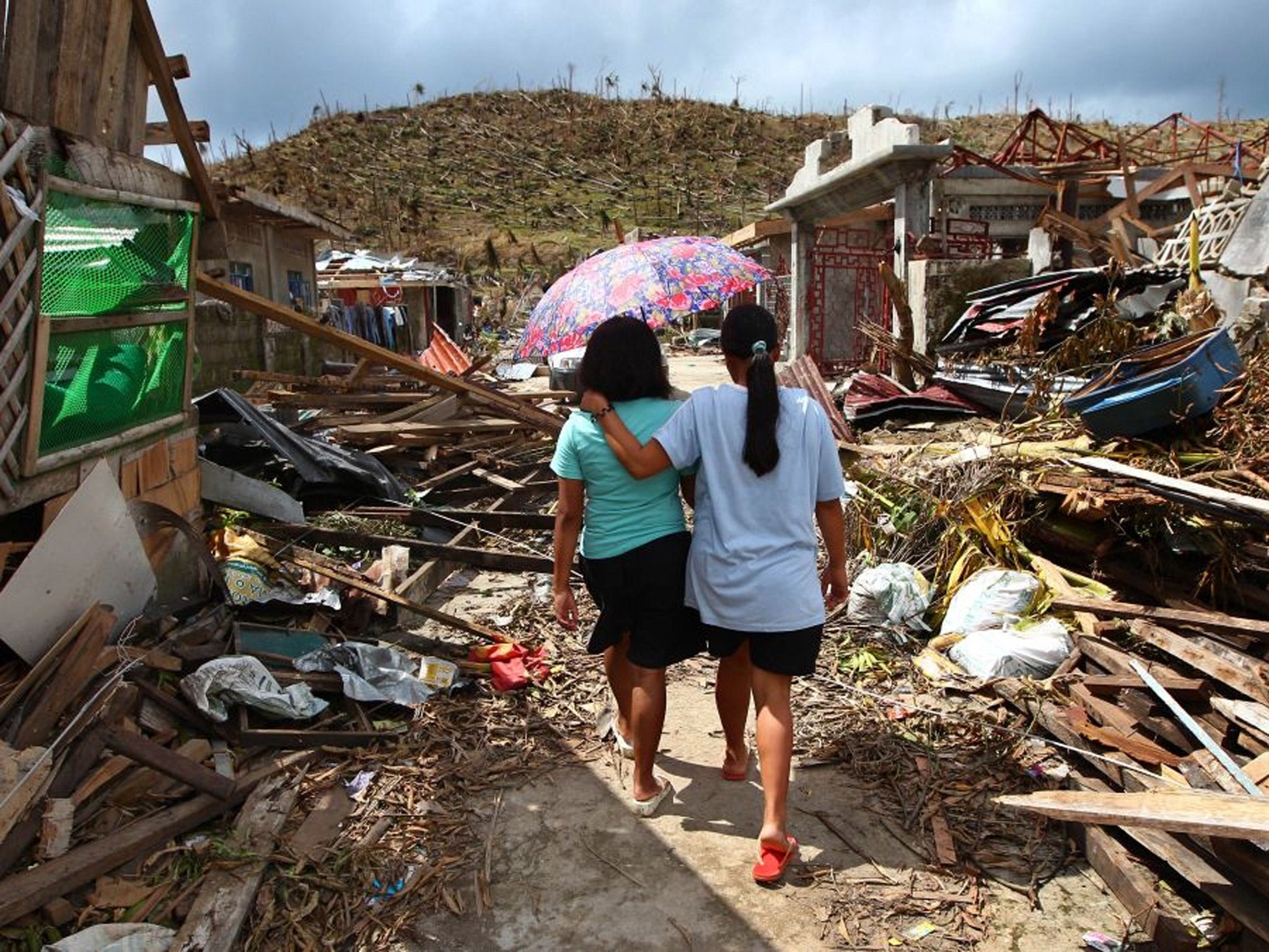 Typhoon Haiyan survivors walk amid ruins of buildings in Maraboth, Philippines